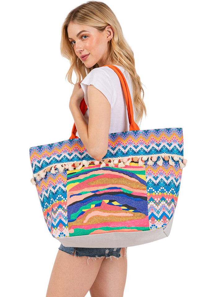 Multi Abstract Boho and Bead Print Pom Pom Tote Bag showcases a sophisticated blend of bohemian artistry and detailed beadwork. Designed for both style and function, this tote offers ample space for daily essentials while featuring eye-catching pom pom embellishments that highlight its handcrafted quality. Ideal for those seeking a unique accessory that complements a refined, boho-inspired wardrobe. 