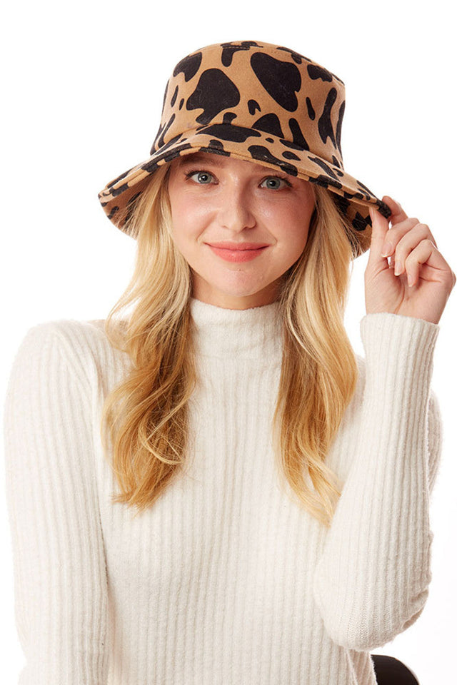 Brown Cow Print Bucket Hat combines a classic silhouette with a trending animal print design. The distinctive black and white pattern offers versatile styling options while providing effective sun protection. Constructed with quality materials for durability, this statement accessory elevates casual outfits with its fashionable farm-inspired aesthetic. 