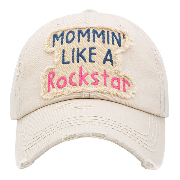 Beige Mommin Like A Rockstar Message Vintage Baseball Cap. Fun cool vintage cap perfect for the mommin who is in Charge! Perfect for walks in sun or rain, great for a bad hair day. Soft textured, embroidered message and distressed contrast stitching baseball cap with fun statement will become your favorite cap. Velcro Adjustable Back