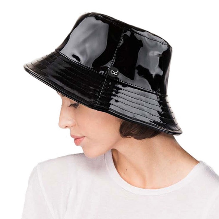 Black C.C Brand Shiny Solid Color Reflective Enamel Detailed Rain Bucket Hat; this rain hat is snug on the head and works well to keep rain off the head, out of eyes, and also the back of the neck. Wear it to lend a modern liveliness above a raincoat on trans-seasonal days in the city. Perfect Gift for fashion-forward friend